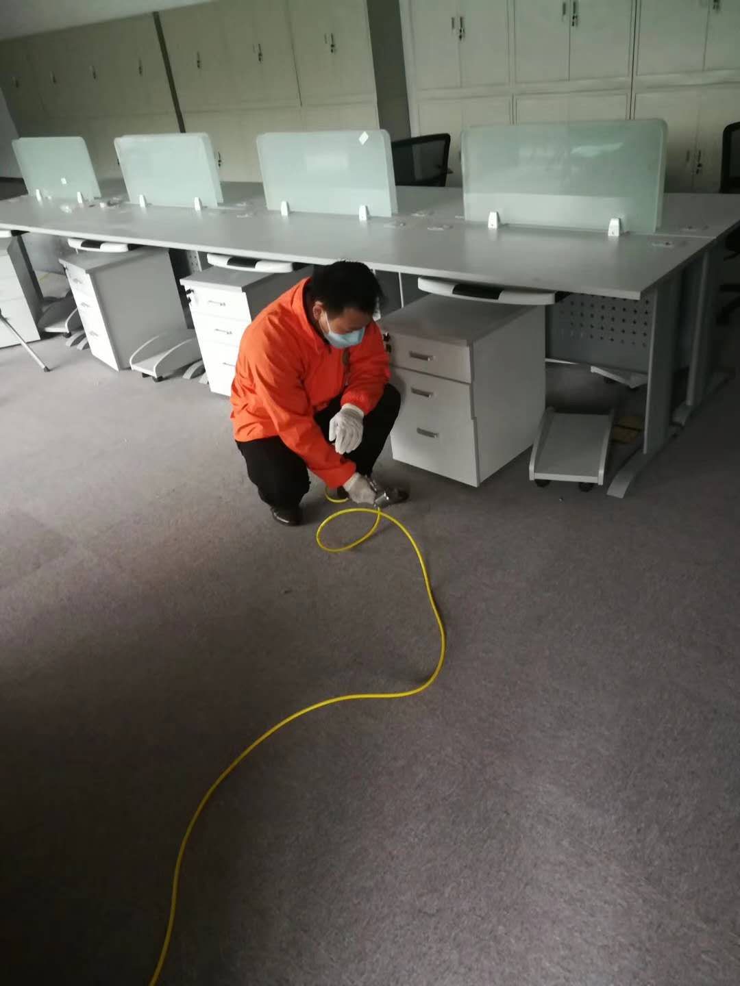 伊甸之家施工人员蹲在开放办公区工位下方的地毯区域作业（农信人寿案例）