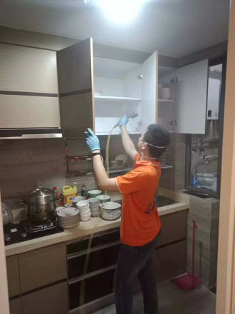 施工人员处理新装修厨房吊柜内部,潮湿季节柜体里的气味更容易闷住(诺德国际案例)